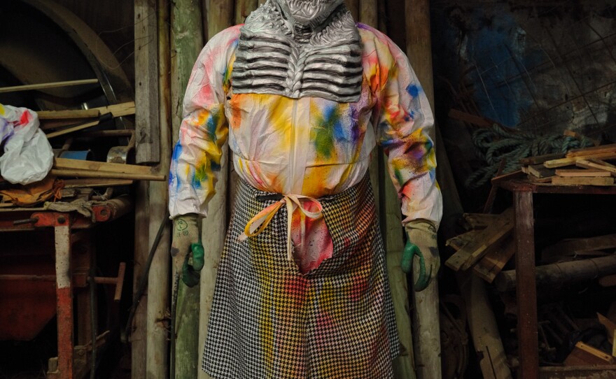 An Okalolie poses inside a clandestine changing room — a small sawmill. The Okalolies are part of a type of visiting custom known as mumming in which young men disguise themselves, visit homes and engage in playful pranks — mainly at Christmas and on New Year's Eve — that have existed in Europe for the past 500 years.