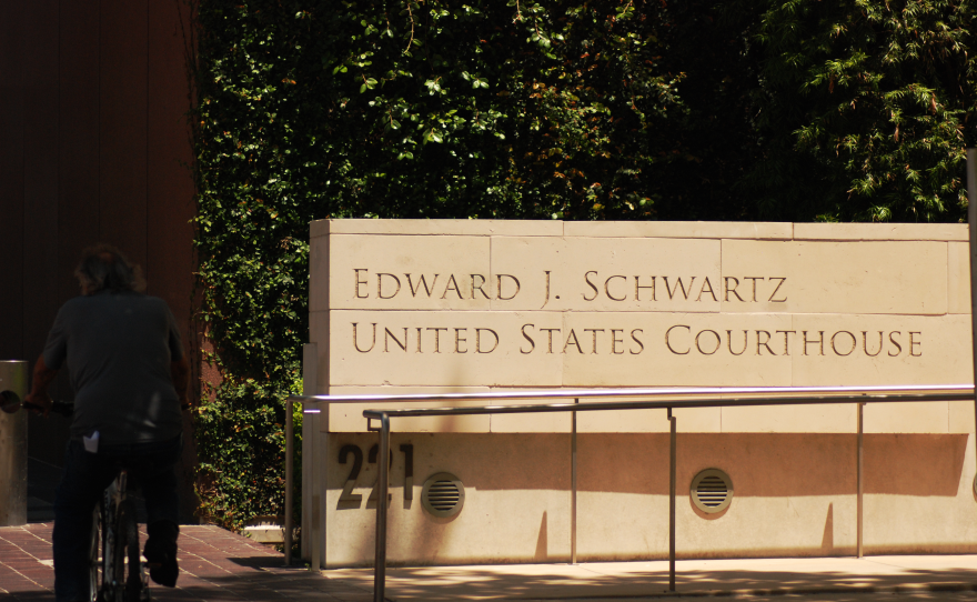 A man biking in front of the Edward J. Schwartz federal courthouse in downtown San Diego, May 21, 2025.