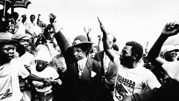 Winnie Mandela raises her fist during the funeral for 17 people who were killed during fierce rioting on Wed. March 5, 1986 in Johannesburg's Alexandra township.