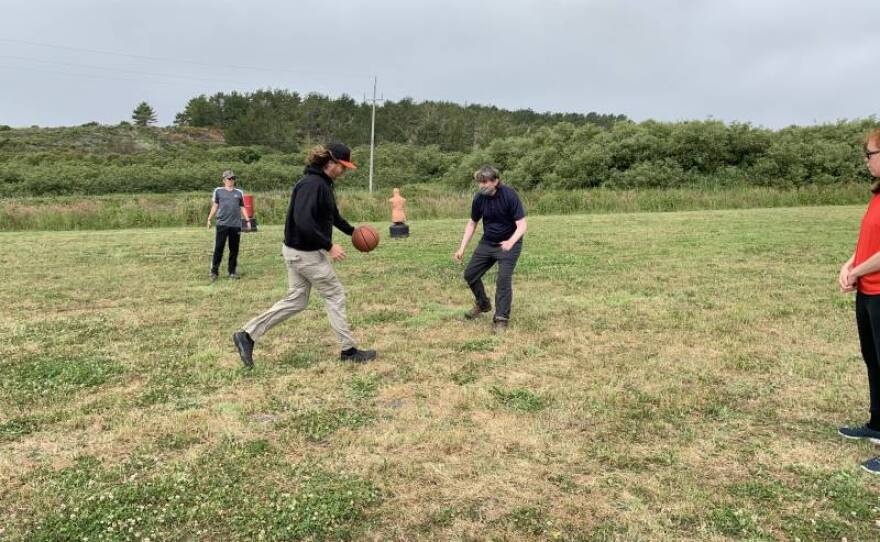 Daniel (with the ball) and Matthew Hearn playing basketball on a field at Big Wave in this undated photo.<br/>