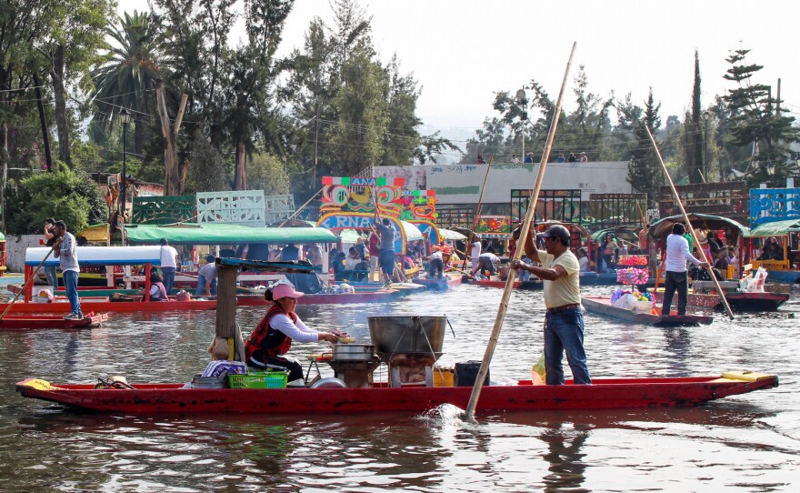A passing chalupa selling roasted corn among a sea of trajineras.
