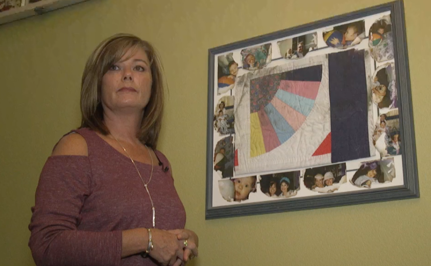Mary Cader with the a quilt her mother made for her and a few baby pictures that survived the Oct 2007 wildfire that destroyed their home in Rancho Bernardo. Sept 27, 2017