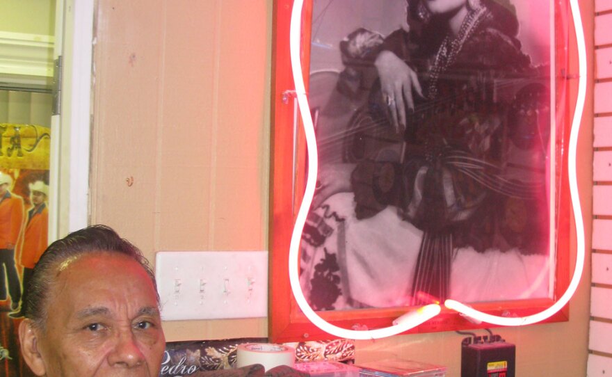 Salome Gutierrez poses next to his shrine for Tejano trailblazer Lydia Mendoza in his San Antonio store, the Del Bravo Record Shop.