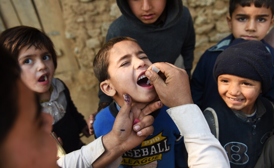 A Pakistani polio vaccination worker gives a dose to a child in Islamabad during a 2014 campaign.