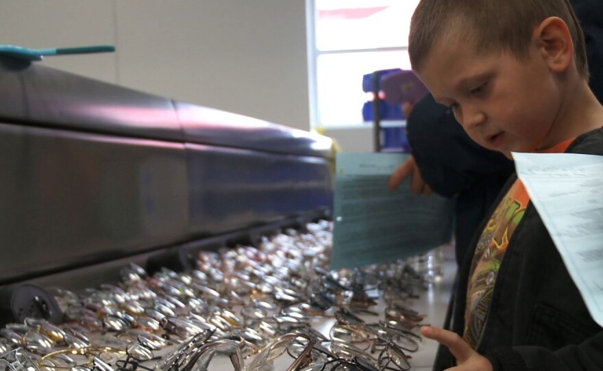 In the documentary Remote Area Medical, a boy chooses a new pair of glasses after receiving an eye exam.