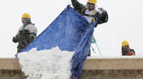 Workers remove snow from the roof of a Home Depot in Methuen, Mass., on Tuesday. After a massive snowstorm, many rooftops in the Northeast were feared to be close to their weight limits.