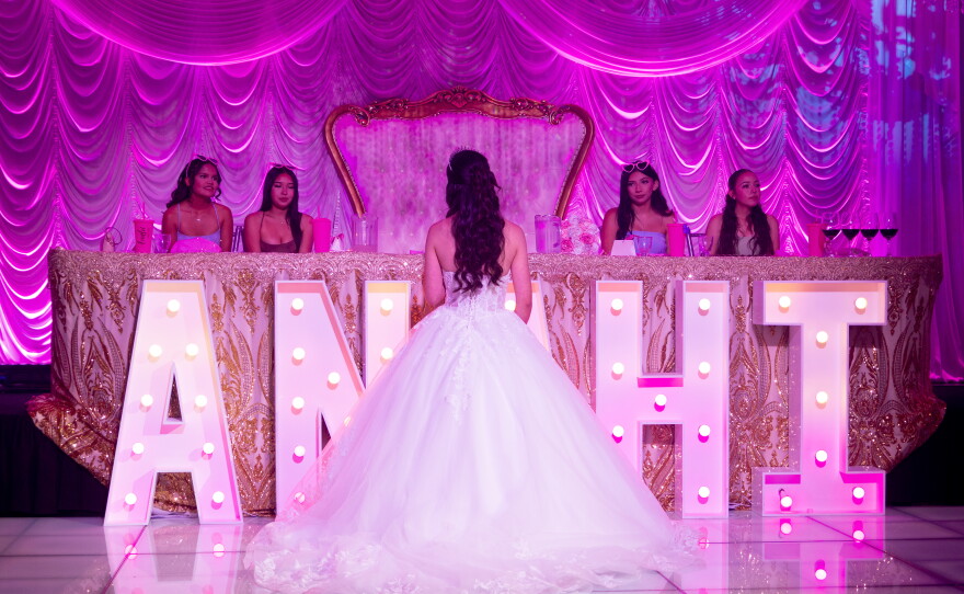 Anahi Sareñana talks to her friends while on stage during her quinceañera at the Factory of Dreams hall in Chula Vista, May 31, 2026.
