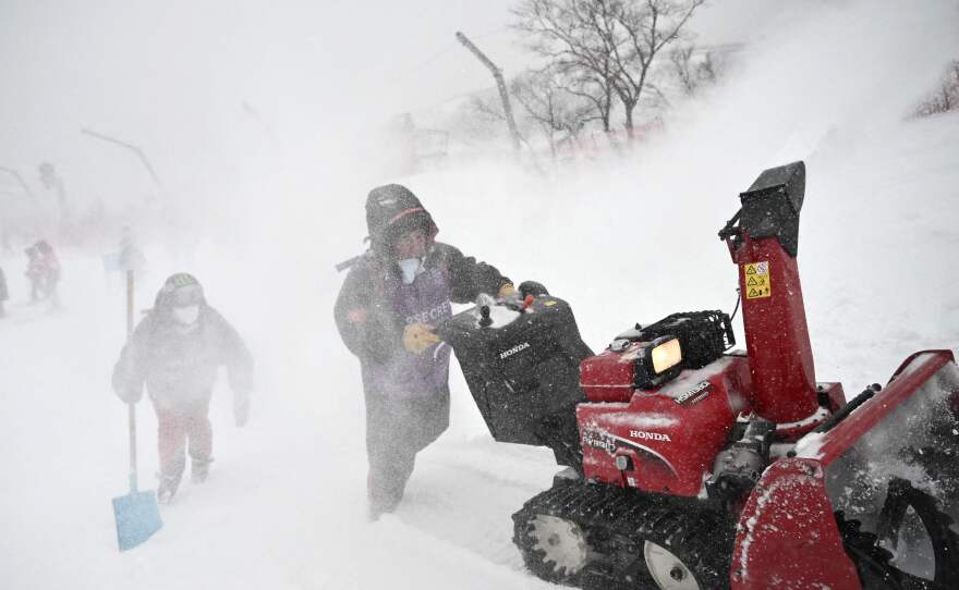 Crew members prepare the course as snow falls ahead of the first run of the men's giant slalom during the Beijing 2022 Winter Olympic Games on Feb. 13.