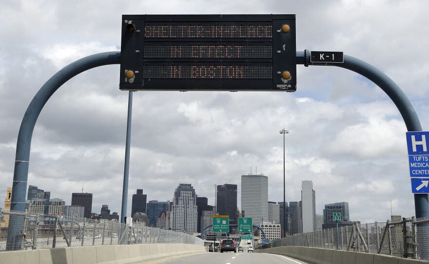 A sign on I-93 alerts motorists that Boston is under a "shelter in place" order Friday.