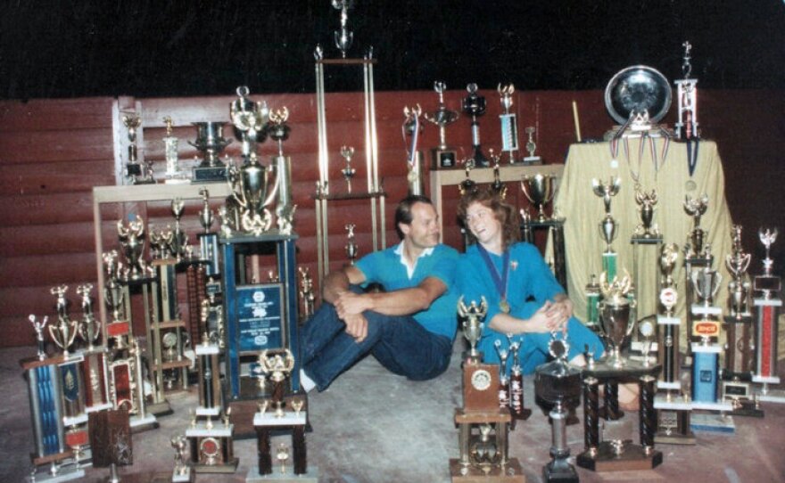 Carolyn and Allen Fisher surrounded by their trophies. They once donated 400 trophies to a thrift store.