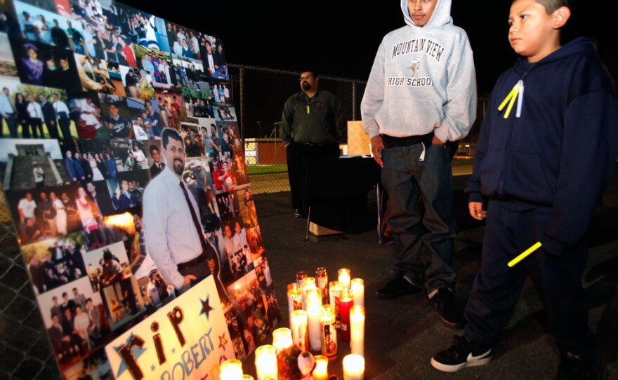 Students Aldo Vazquez (left), 17,  and Juan Guerero, 10, pause next to a photo of late Bobby Salcedo during a vigil at Mountain View High School in El Monte, Calif., on Monday.