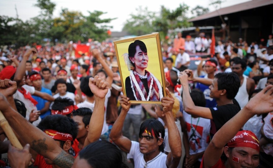 A man holds a portrait of Myanmar opposition leader Aung San Suu Kyi during a rally for a candidate of her National League for Democracy party on Friday. The country is holding elections for some parliamentary seats on Sunday.