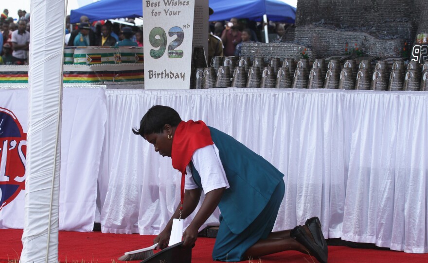 A woman cleans the carpet during birthday celebrations for Zimbabwean President Robert Mugabe on Saturday in Masvingo, about 300 kilometres south of Harare, Zimbabwe.