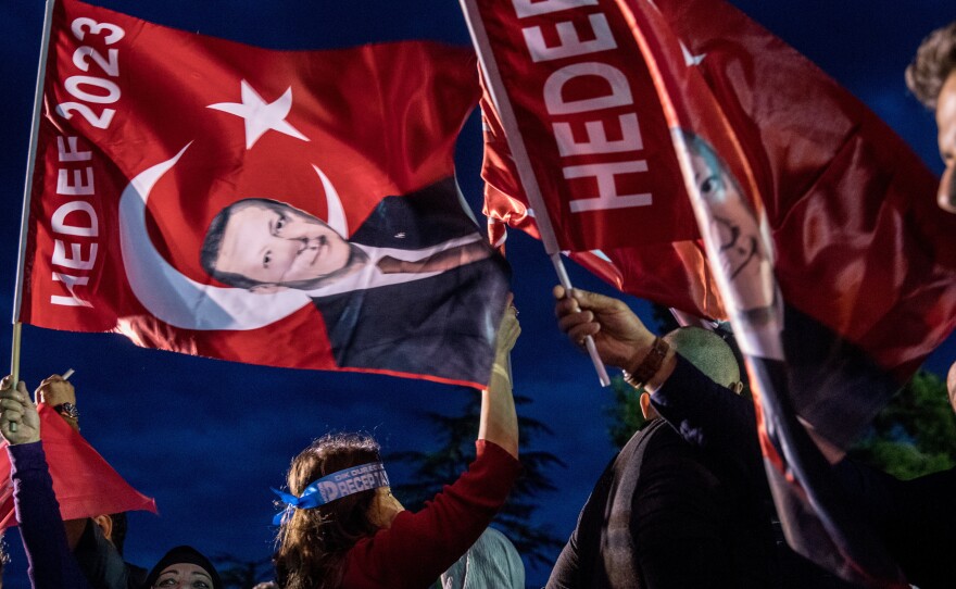 Supporters of Turkey's President Recep Tayyip Erdogan gather in front of the Huber Presidential Palace, where he delivered a victory speech. Preliminary results indicate Erdogan has avoided a runoff.