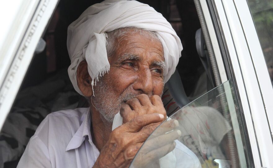 Muhammad Azeem, Qandeel Baloch's father, sits in an ambulance carrying the body of his daughter on July 17. He has called for his son to be punished for committing the murder.