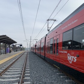 A red MTS trolley car sits at the Balboa Avenue station on the extension of the UCSD Blue Line, Nov. 18, 2021.