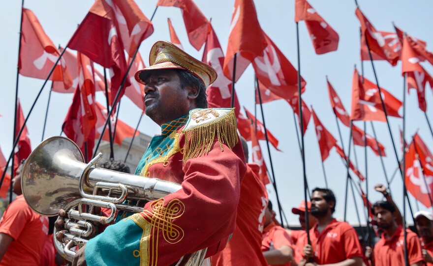 Indian workers and members of various trade unions dressed in red take part in a rally on the occasion of International Workers' Day in Bangalore on Monday.