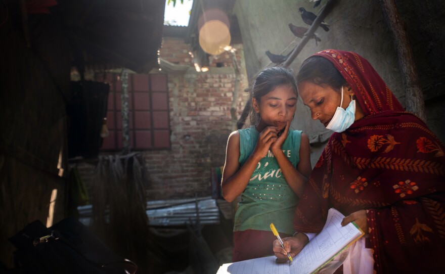 Community health worker Bulbul Aktar handwrites her notes to keep track of the spread of malaria.