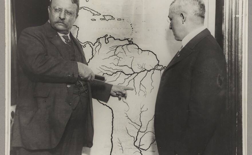 President Roosevelt pointing at a map of South America towards the area explored during the Roosevelt-Rondon Scientific Expedition in Brazil.