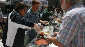 San Marcos High School senior Xiamora Martinez serves up a bowl of chili to Michael Lawson, director of the North County Community Services Food Bank. Two San Marcos high schools partner with the food bank for Empty Bowl fundraisers.
