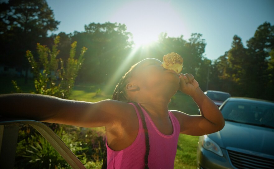 The photographer's cousin Miyah eats a caramel apple days before Halloween. The picture is part of the series, "Not Forgotten: An Arkansas Family Album."