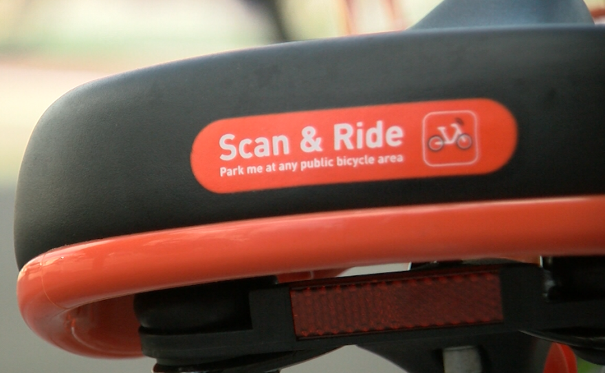 Text on the back of a Mobike seat reads, "Scan & Ride," March 23, 2018.