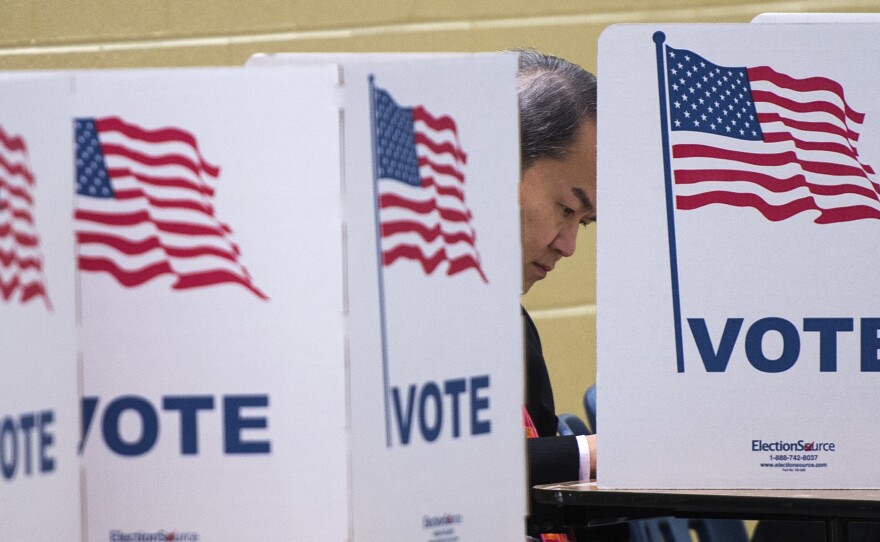 A man votes at a polling place in McLean, Va., in 2016. Currently, polling places are largely a politics-free zone, but the Supreme Court hears arguments that could change that.