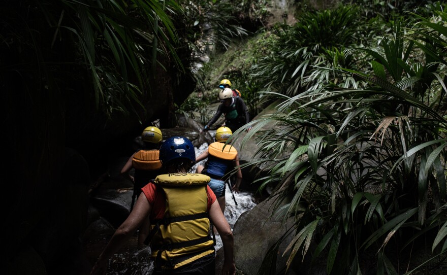 While rafting down the Guejar River, tourists stop to hike along a stream to a waterfall near the town of Mesetas, which used to be under FARC rebel control in southern Colombia.