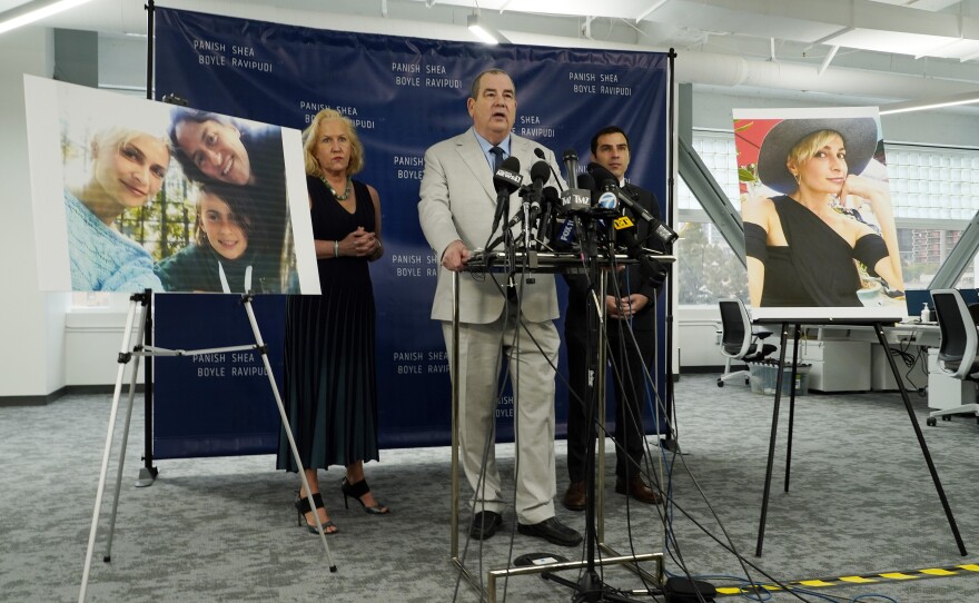 Randi McGinn, from left, Brian Panish and Jesse Creed, attorneys for the family of cinematographer Halyna Hutchins, take part in a news conference alongside portraits of Hutchins and her family, Feb. 15, 2022, in Los Angeles.
