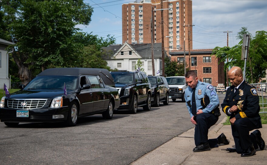 Minneapolis Police Chief Medaria Arradondo (right) kneels as the hearse of George Floyd arrives to North Central University ahead of funeral service on Thursday. Protests in the wake of Floyd's death while in police custody has erupted across the country.