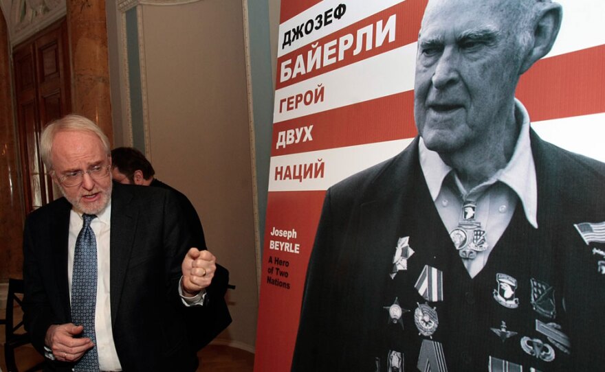 U.S. Ambassador to Russia John Beyrle attends the opening of the exhibition devoted to his father, Joseph R. Beyrle, seen in photo at right, in St. Petersburg, Russia, on Feb. 18. The exhibit is currently in Moscow.