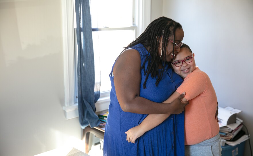 Holly Rodriguez hugs her youngest son, Iommi, at her home in Richmond, Va.