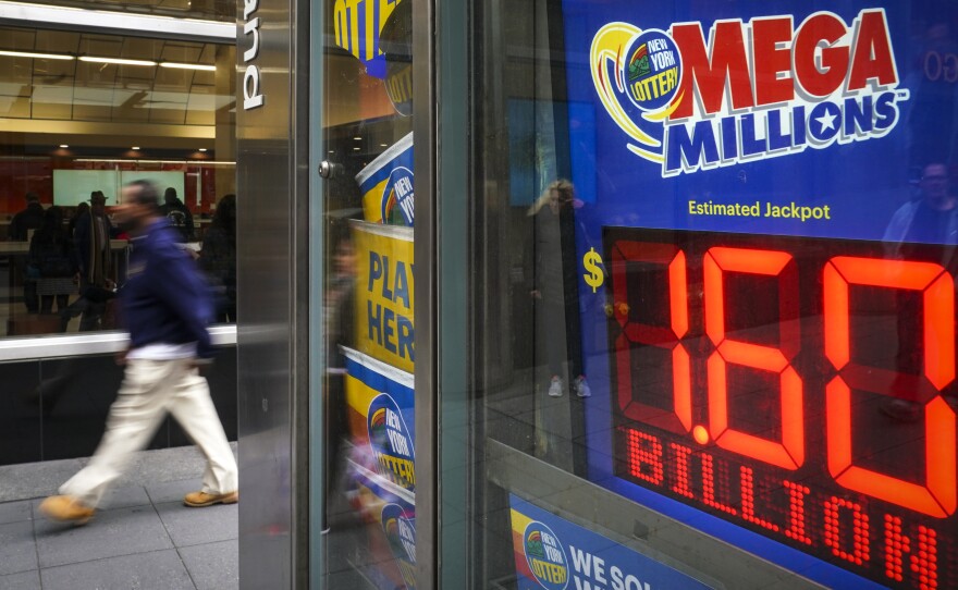 A man walks past a newsstand with advertisements for the Mega Millions lottery on Tuesday in New York City. The $1.537 billion Mega Millions winning lottery ticket was sold in South Carolina.