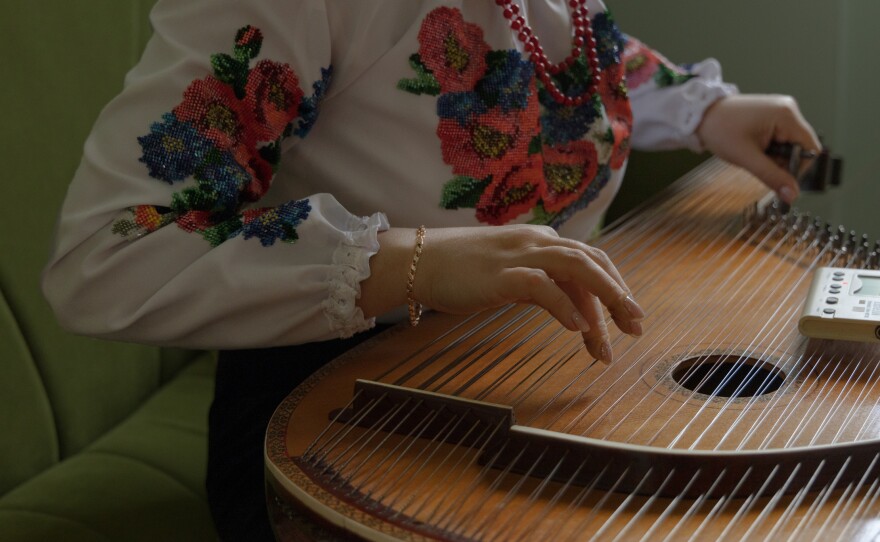 Olena Melnyk tunes the bandura, Ukraine's national instrument, in Ravenna, Italy, in January 2023. Olena works as a caregiver, but she studied to be a professional bandora musician. Today, she uses the instrument to bring people closer to her culture.
