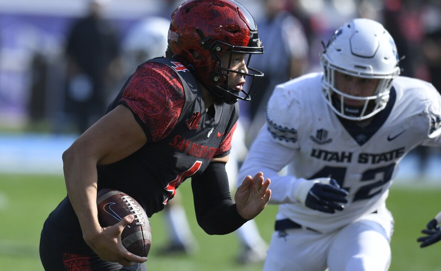 San Diego State quarterback Jordon Brookshire (4) runs away from Utah State defensive end Nick Heninger (42) in the first half during an NCAA college football game for the Mountain West Conference Championship, Saturday, Dec. 4, 2021, in Carson, Calif.