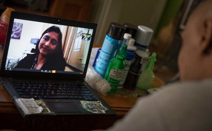 Dr. Gita Agarwal of Mary's Center conducts a telemedicine conference with Dennis Dolman from his mother's house in Washington, D.C.