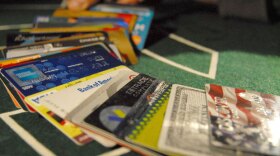 As credit card companies face new regulation from Washington, "FRONTLINE" examines the future of the massive consumer loan industry. Pictured: Credit cards fanned across the top of a card table. 