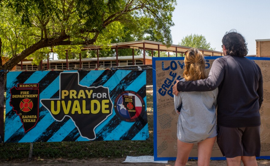 Siblings Kiley and Michael Regenthal pay their respects at a memorial in front of Robb Elementary School on June 17, in Uvalde, Texas.