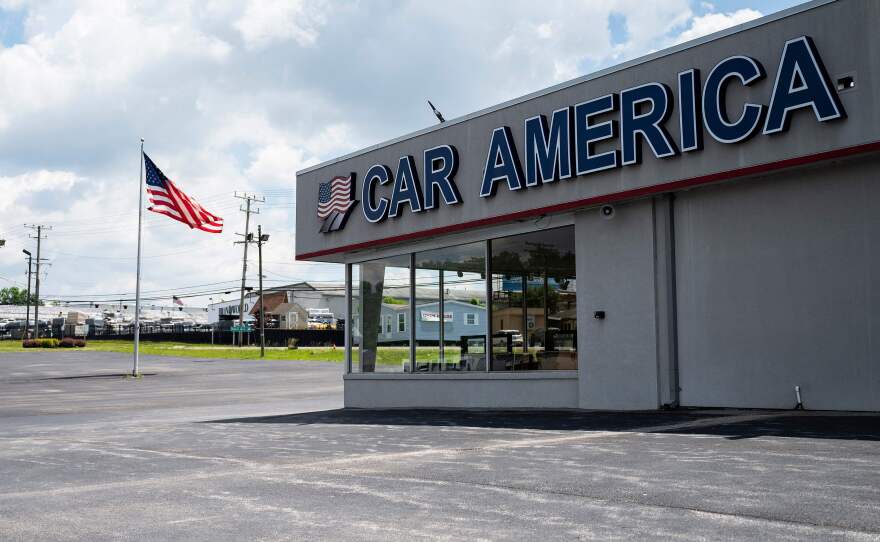 A car dealership stands empty in Laurel, Md., on May 27, 2021, as many car dealerships across the country are running low on new vehicles because of a computer chip shortage. It's months later, and auto makers are still struggling to meet demand.