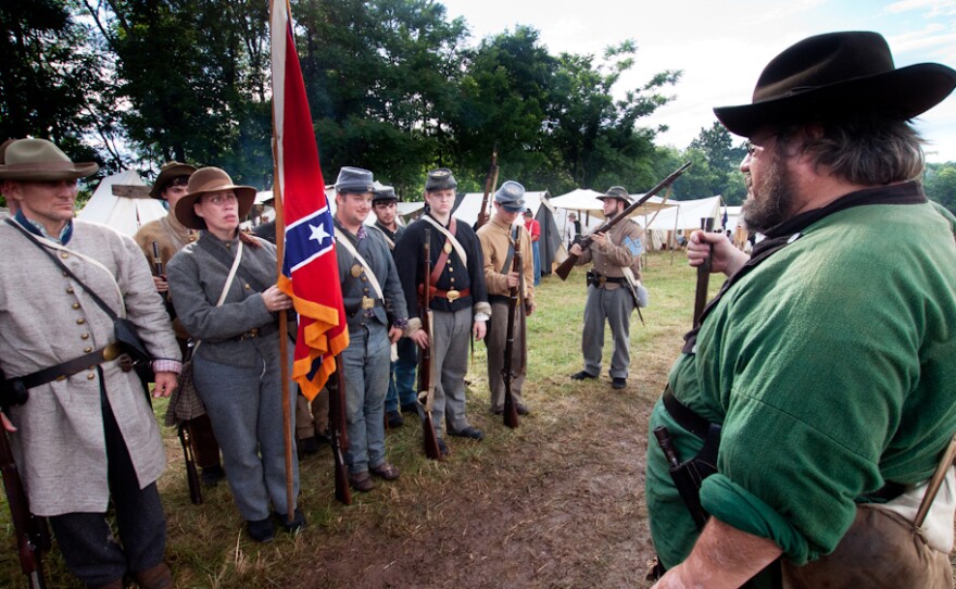 Waverly Adcock, a sergeant and founder of the West Augusta Guard, prepares his company for inspection and battle at a Civil War reenactment in Virginia. Sara Smith, whose great-great grandfather was wounded at the Battle of Gettysburg, holds the Confederate battle flag.