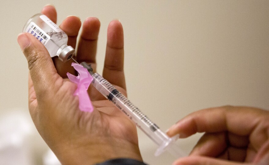 A nurse prepares a flu shot at the Salvation Army in Atlanta last month. The disease is still "widespread" in many places, but slowing.