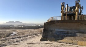 A construction vehicle sits atop a dirt hill near the U.S.-Mexico border at the location for the future Otay Mesa East port of entry, Nov. 18, 2022.