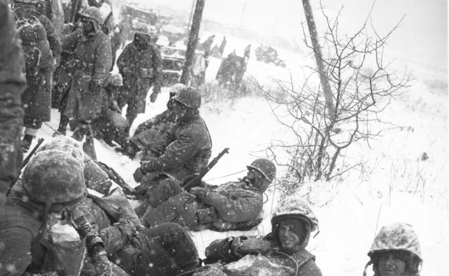 Men of a U.S. Marine mortar squad rest at the side of a snowy road during their withdrawal from the Chosin Reservoir, North Korea. Dec. 8, 1950.