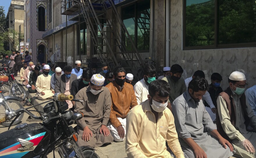 Dozens of worshippers pray outside the Haidari Mosque in the Pakistani capital of Islamabad.