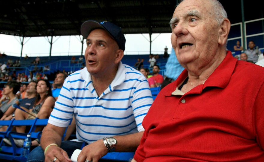 Ismael Sené (right), a former intelligence agent turned baseball historian, watches a game at Latin American Stadium.