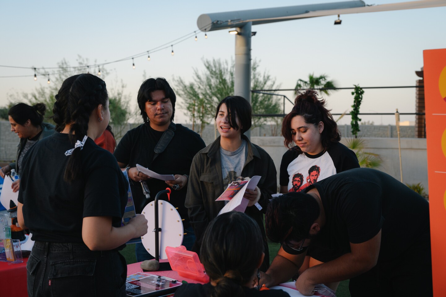 Attendees chat with Imperial Valley Equity and Justice Coalition organizer Fernanda Vega during an information event organized by the ACLU’s Imperial Valley team, along with five other local advocacy organizations, on Oct. 18, 2024. The coalition is hoping to register hundreds of new voters and get people energized about casting their ballots ahead of the November election.