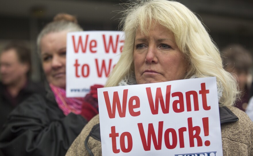 IRS employee Pam Crosbie and others hold signs protesting the government shutdown at a federal building in Ogden, Utah.