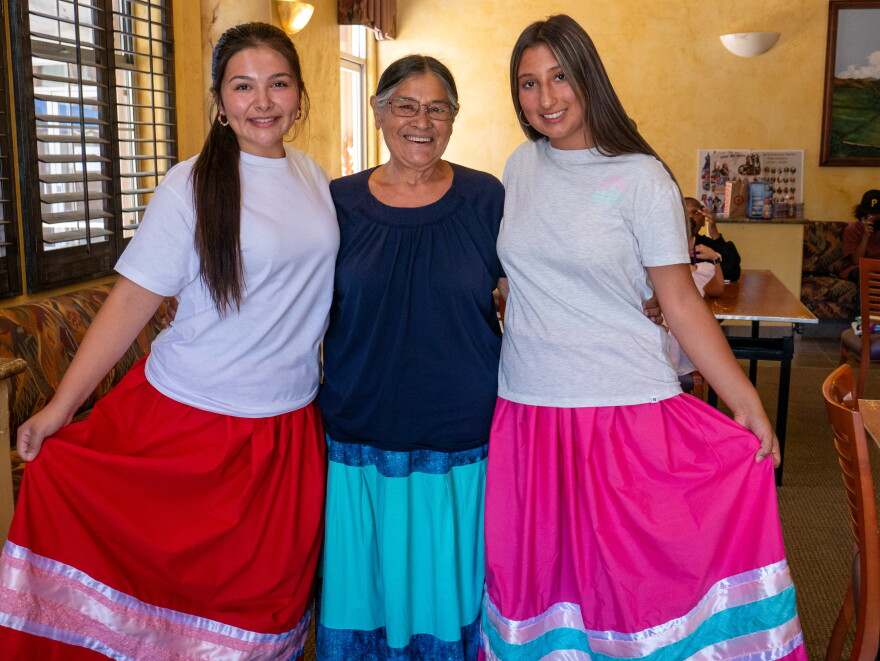 Alana Castillo (left), Melody Sees and Talia Boller (right) stand for a photo wearing their ribbon skirts at the Barona Community Center on July 21, 2026.