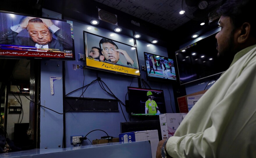 A Pakistani court sentenced former military ruler Pervez Musharraf to death Tuesday, on charges of high treason and subverting the constitution. Here, a shopkeeper watches TV coverage of the news at a shop in Karachi.