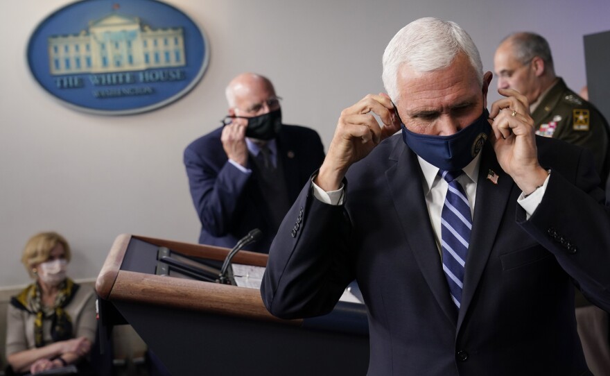 Vice President Pence adjusts his face mask during a news conference with the coronavirus task force at the White House on Nov. 19.